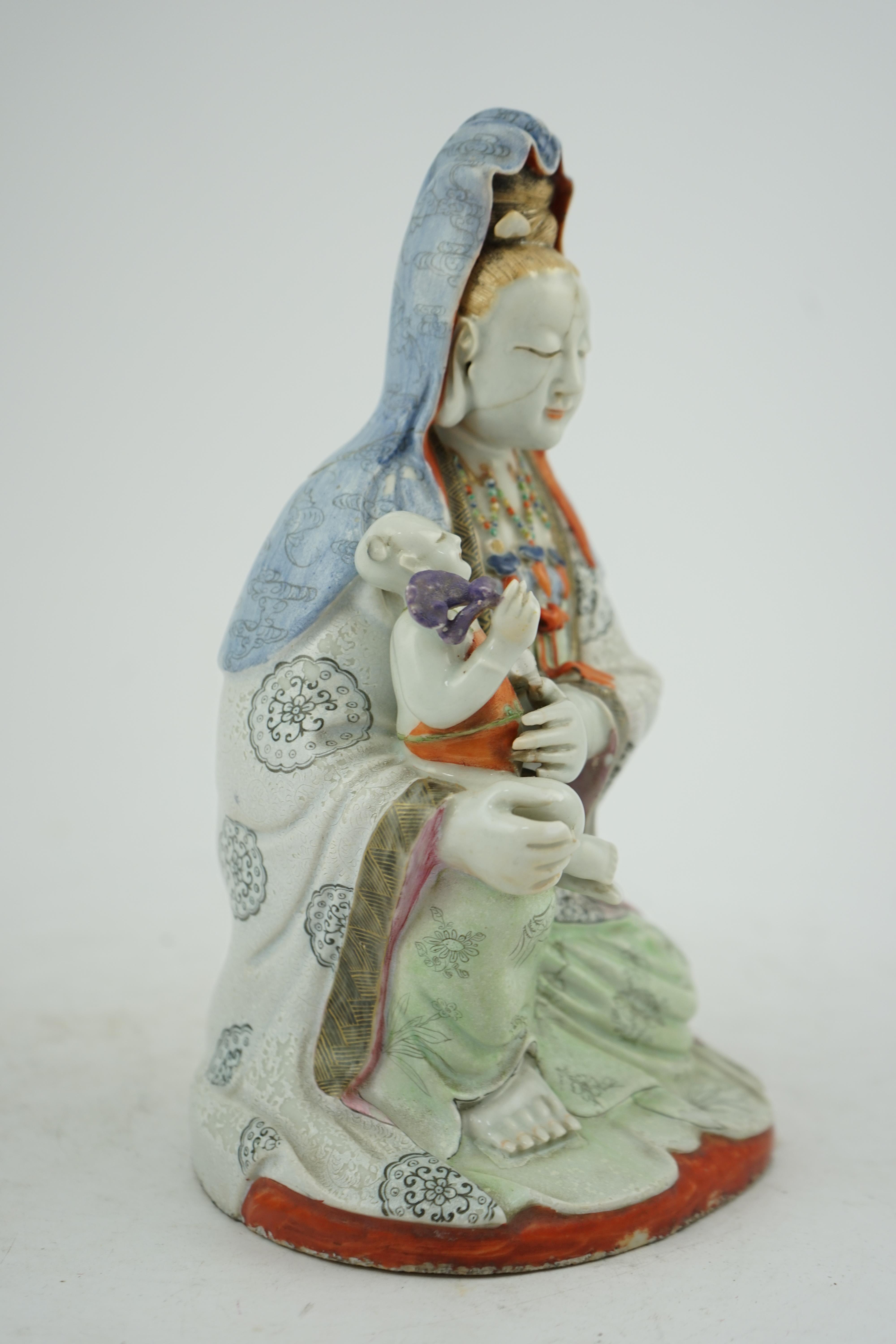 A Chinese enamelled porcelain group of Guanyin holding a child, Qianlong period